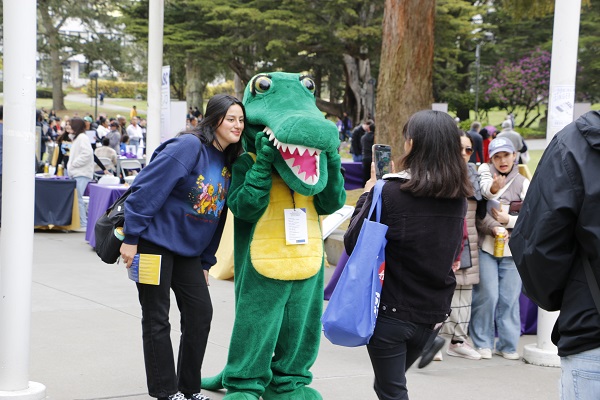 Students pose with a person in a Gator suit