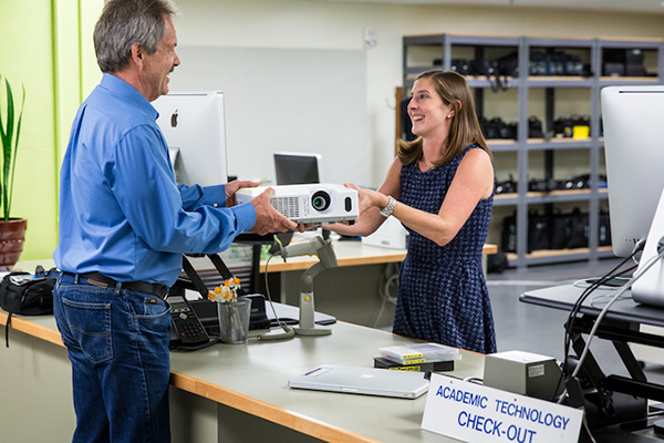 A projector being checked out from Academic Technology desk