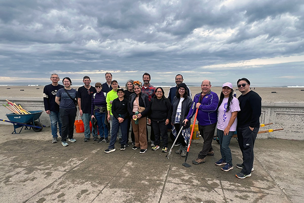 Advancement team posed in front of ocean beach