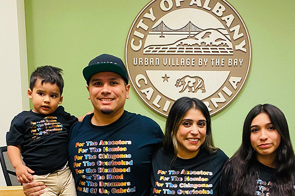 Robin López smiling with her family in front of the Albany city seal.