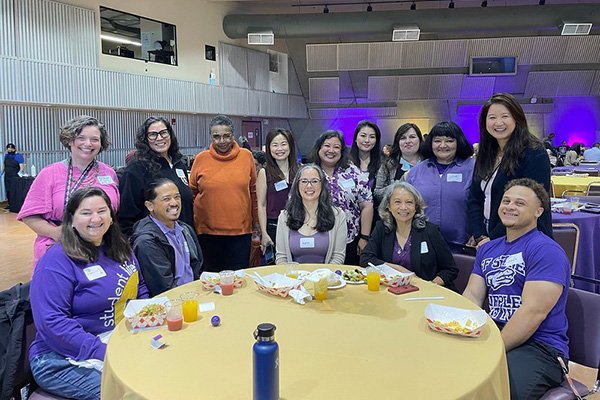 a group of alumni sitting on a banquet table enjoying lunch