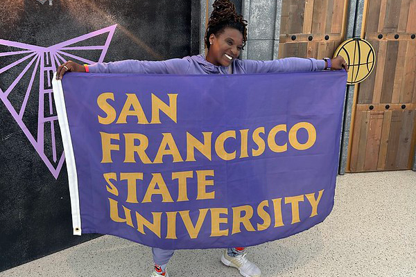 Alum proudly displays an outstretched SFSU flag