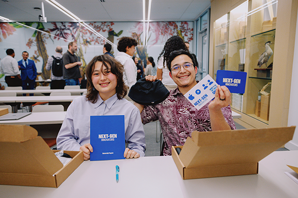 Two SFSU students proudly pose with their Apple Next-Gen Innovators mentorship cards and brochures.