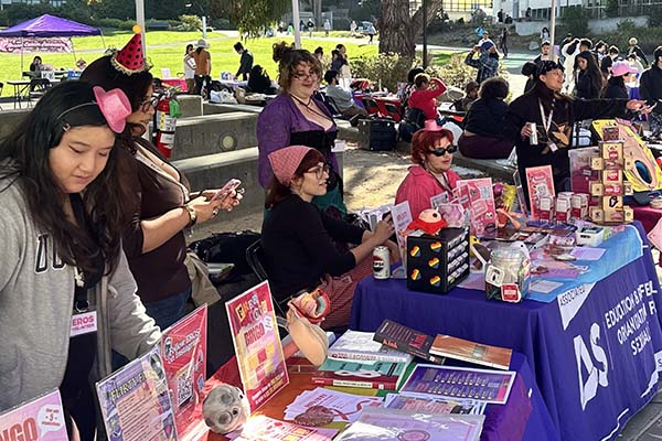 SFSU organization tabling with volunteers wearing fun hats