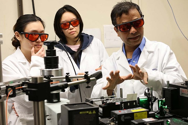 AKM Newaz consults with two students in the lab