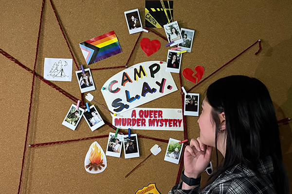 Student examining an evidence board of clues from Camp S.L.A.Y.