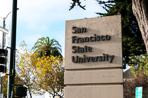 A pylon reading “San Francisco State University,” with trees in the background.