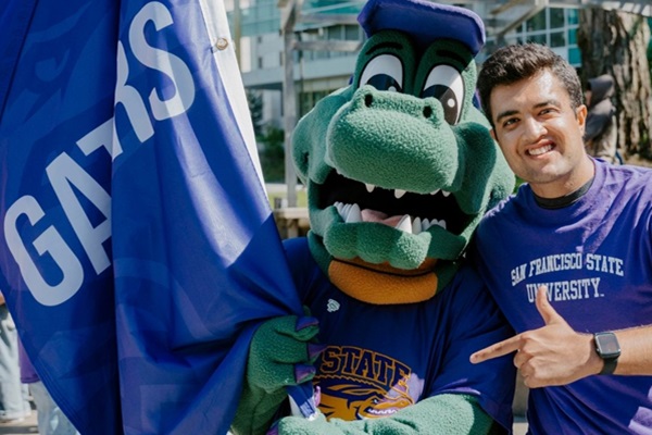 A person in an alligator suit stands with a smiling man