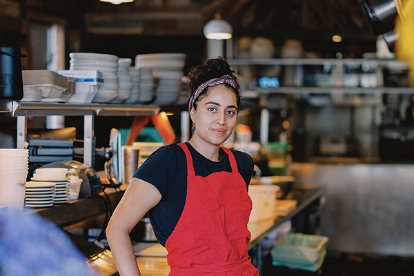 SFSU Alum Brenda Landa with commercial kitchen background
