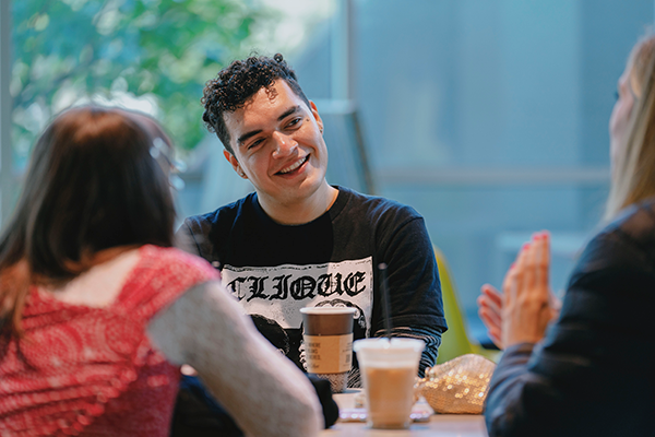 SFSU students having conversation inside library over coffee drinks