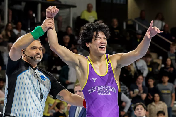 A referee holds up the hand of a jubilant Johnny Lopez