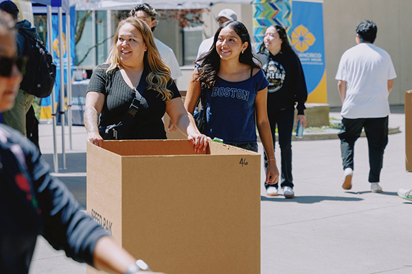 Incoming students at move in day rolling in their bins