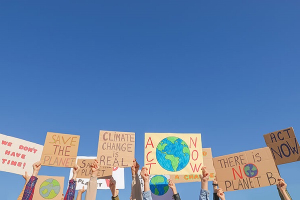 Hands hold up signs with environmental messages
