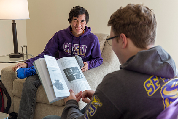 two SF State students discussing and reading a book