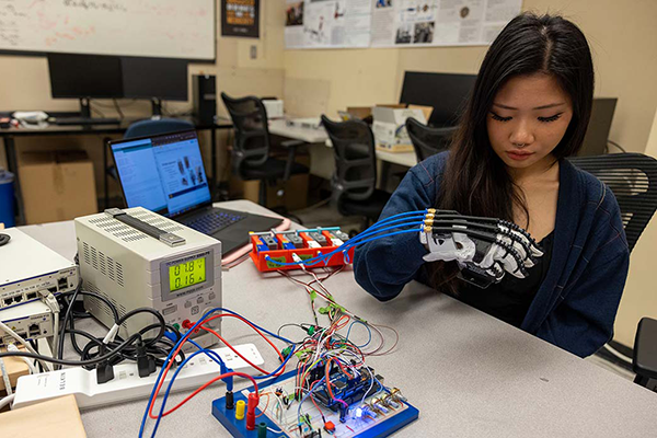 a female student wearing a prototype of a robotic glove