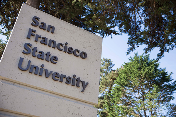 A pylon reading “San Francisco State University,” with trees in the background.