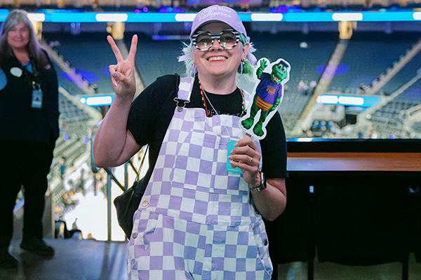 SFSU student in Chase Stadium poses with Alli the Gator cutout flier