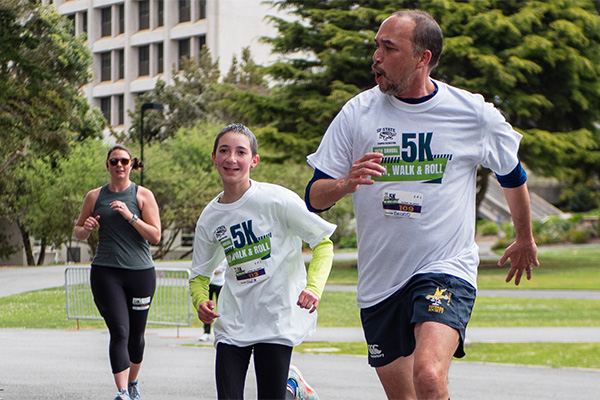 Three participants in Campus Rec’s 5K Run, Walk and Roll make their way along the campus course.