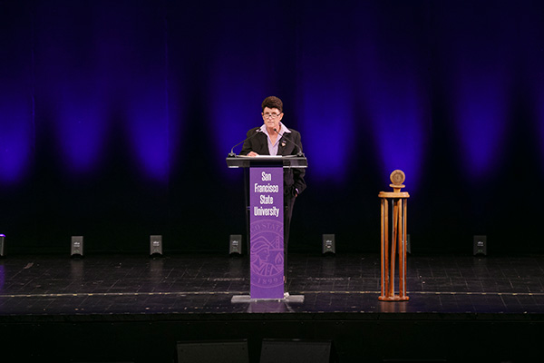 President Lynn Mahoney speaking on stage at Convocation