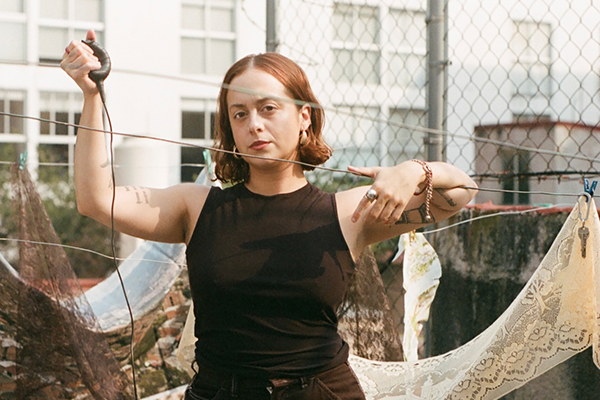 Paola de la Calle poses from within one of her art installations.