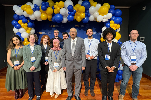 Students pose for a photo beneath a balloon arch at the CSU Research Competition.